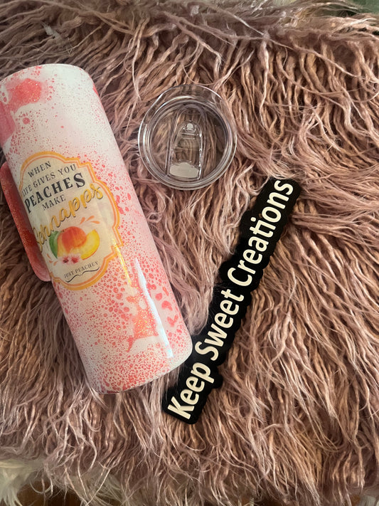 20 oz tumbler with handle, pink splatter design, mason jar graphic, and “When life gives you peaches, make peach schnapps” quote; includes lid and straw