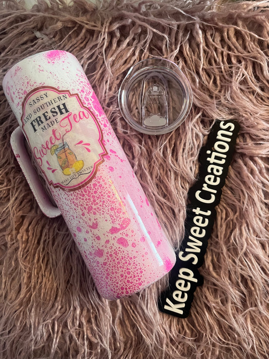20 oz tumbler with handle, pink splatter background, and “Sassy and Southern, Fresh Made Sweet Tea” design; includes lid and straw