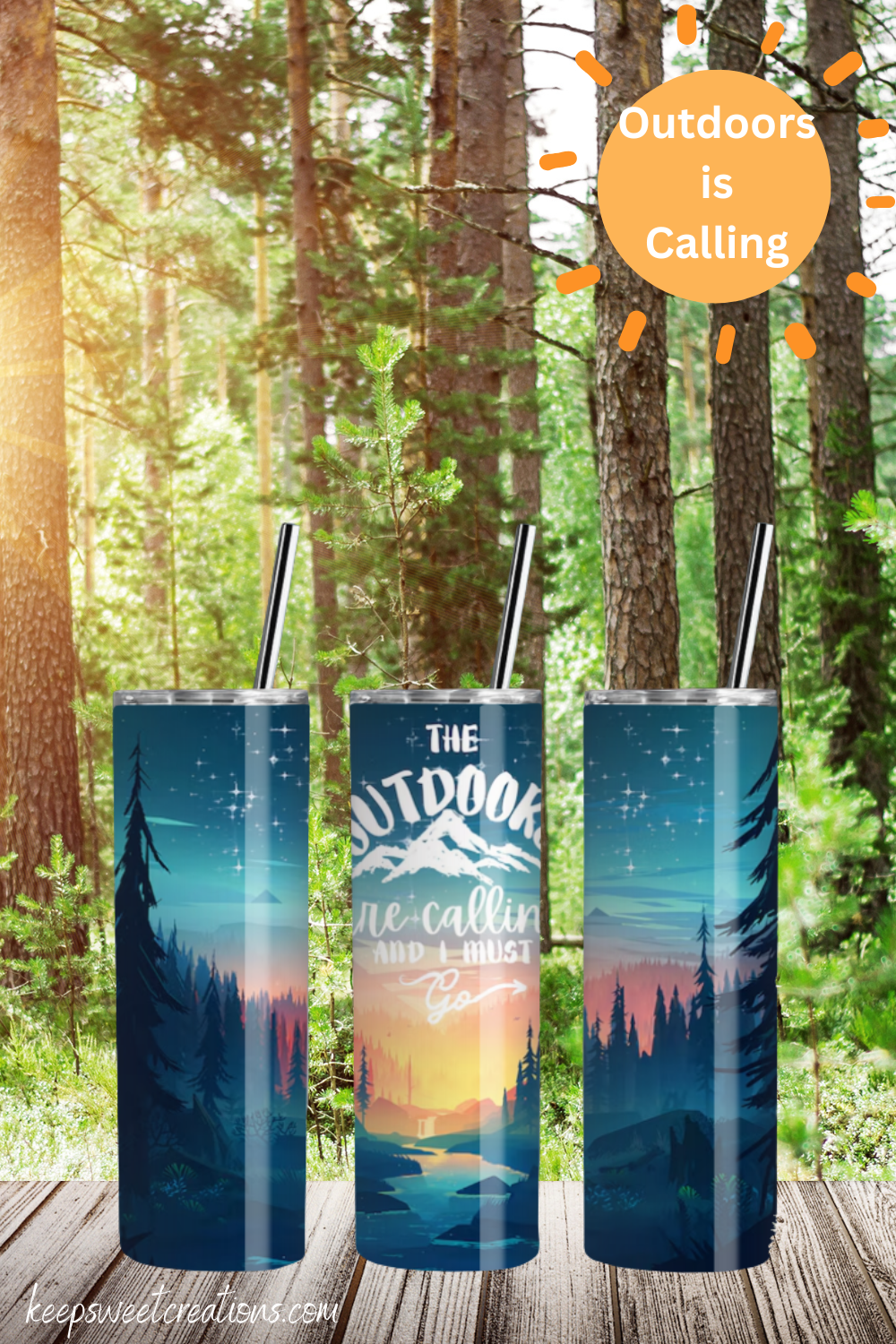 A stainless steel tumbler with a scenic outdoor design, featuring a mountain sunset, tall pine trees, and a reflection on a calm lake. The tumbler displays the phrase "Outdoors is Calling" in elegant script. The set includes tumblers with both metal straws and black flip-top lids. The background varies, including wood textures and white brick walls, enhancing the nature-inspired aesthetic.