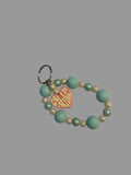 Turquoise beaded keychain with a heart-shaped tag on a light surface