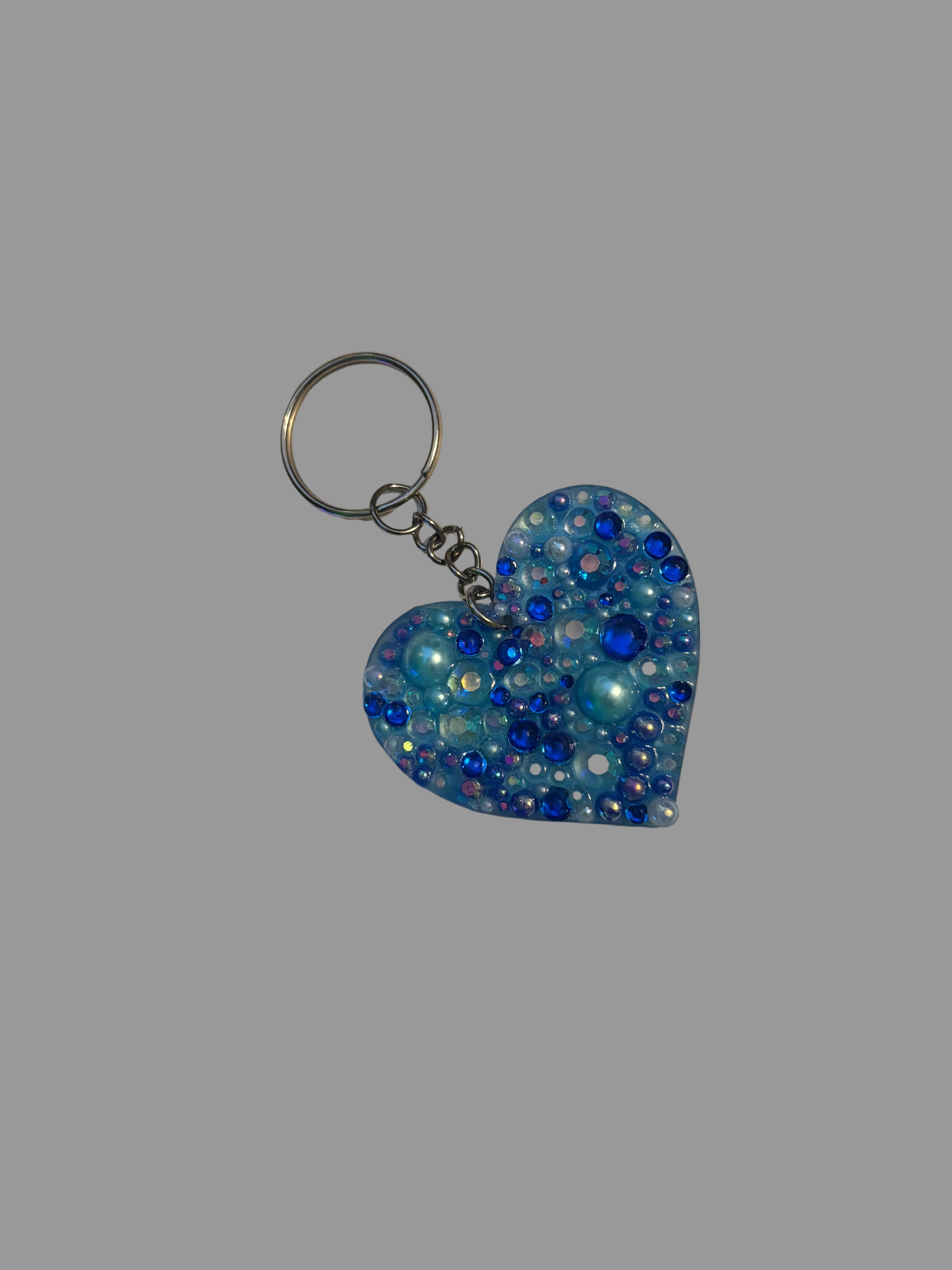 Heart-shaped keychain with blue beads on a light surface