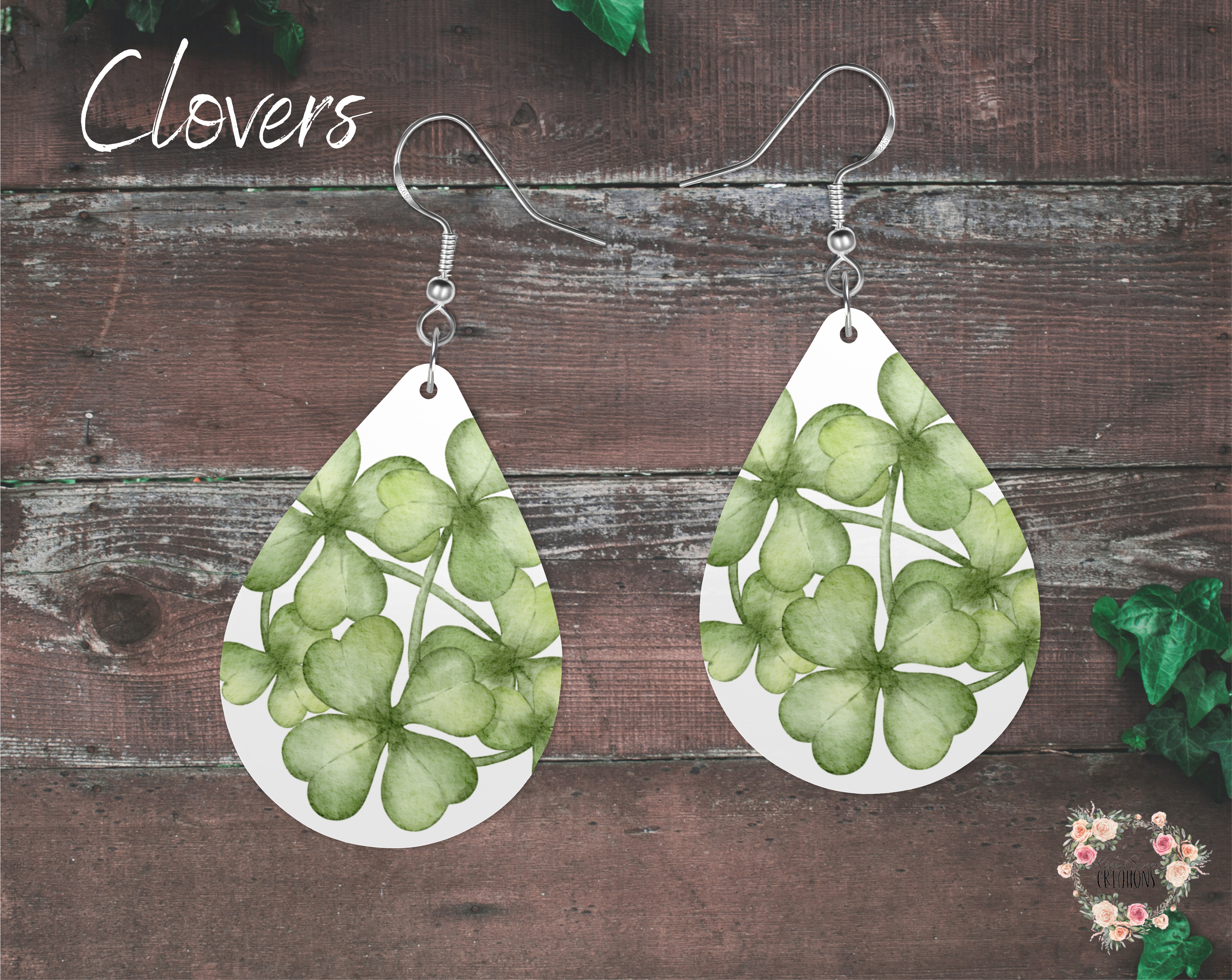 "A pair of teardrop-shaped St. Patrick’s Day earrings featuring a watercolor-style design of green shamrocks on a white background. These elegant and festive earrings are made from lightweight sublimation wood with nickel-free hypoallergenic hooks, perfect for adding a subtle Irish touch to any outfit."