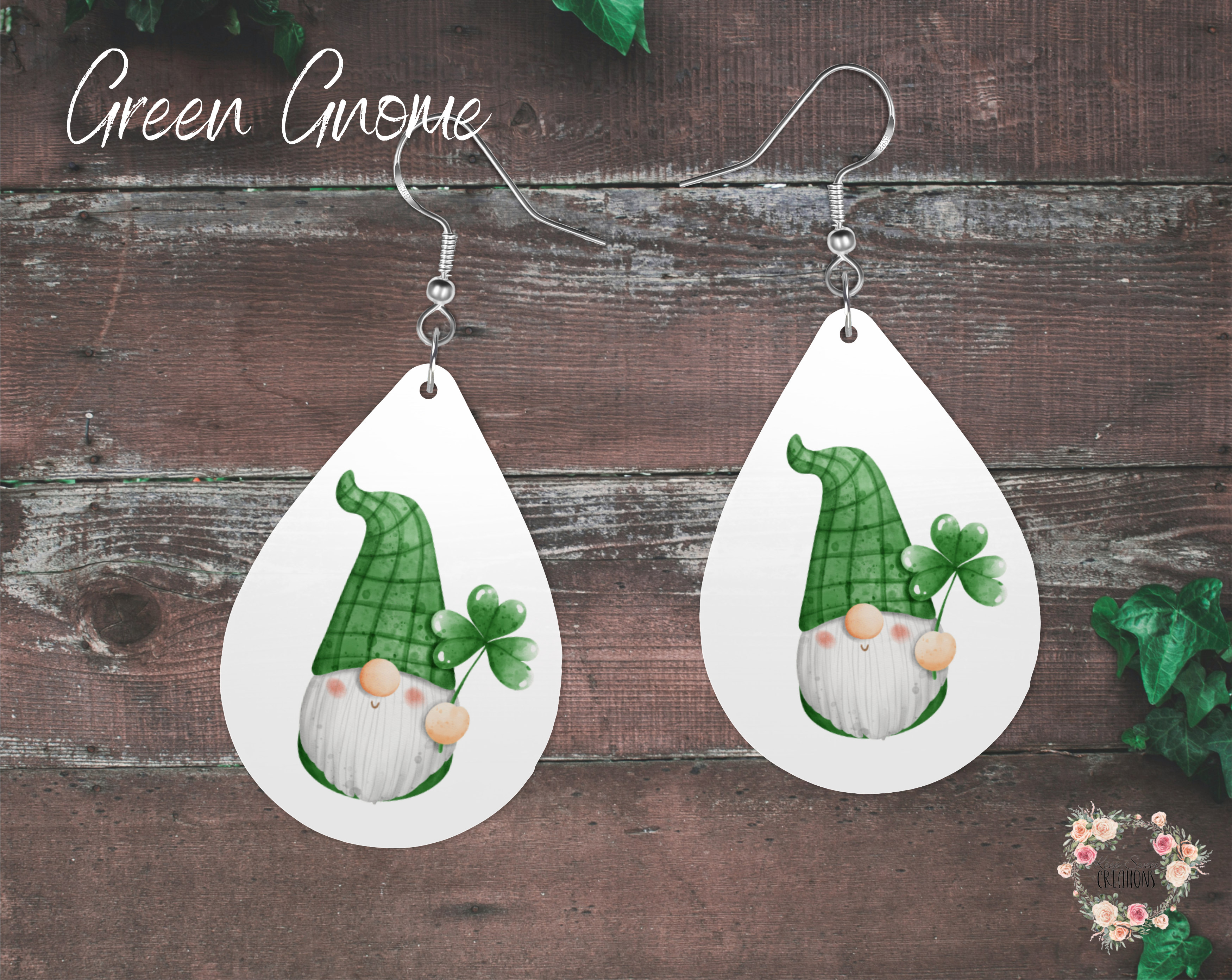"A pair of teardrop-shaped St. Patrick’s Day earrings featuring a cute green gnome holding a shamrock. The gnome has a plaid-patterned hat and a white beard, set against a clean white background. These lightweight sublimation wood earrings have nickel-free hypoallergenic hooks, making them a festive and fun accessory for the holiday."