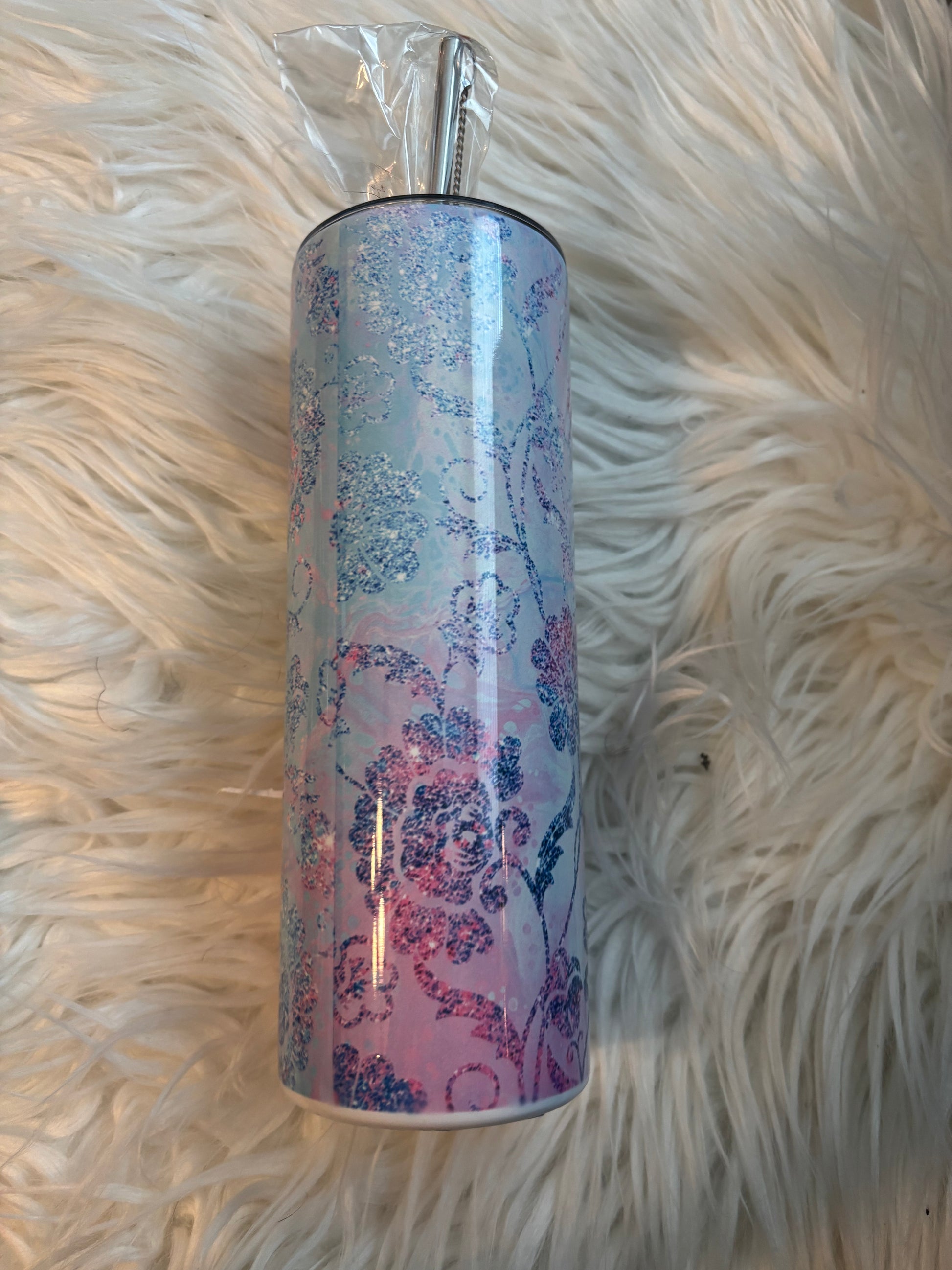 20 oz stainless steel tumbler with pink and blue floral sublimation design on a faux fur background