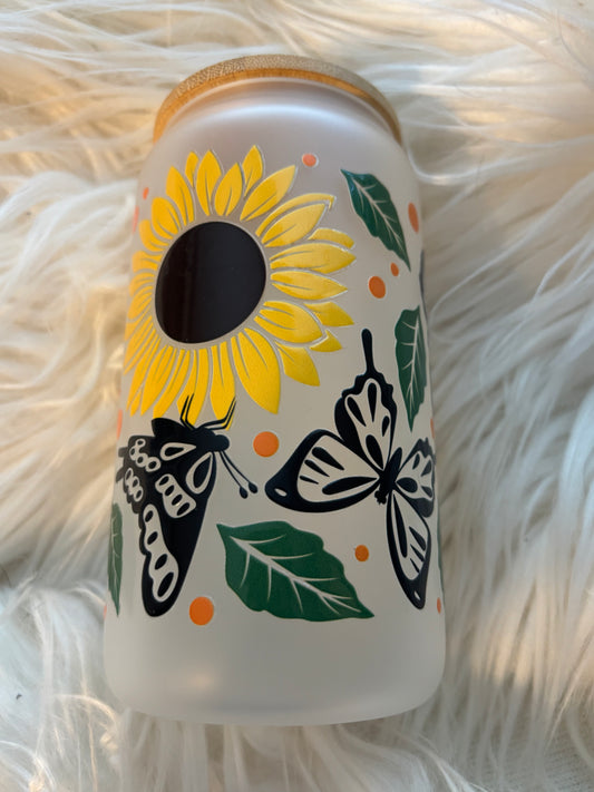 Sunflower and butterfly UVDTF decal on frosted glass tumbler with green leaves and bold floral design