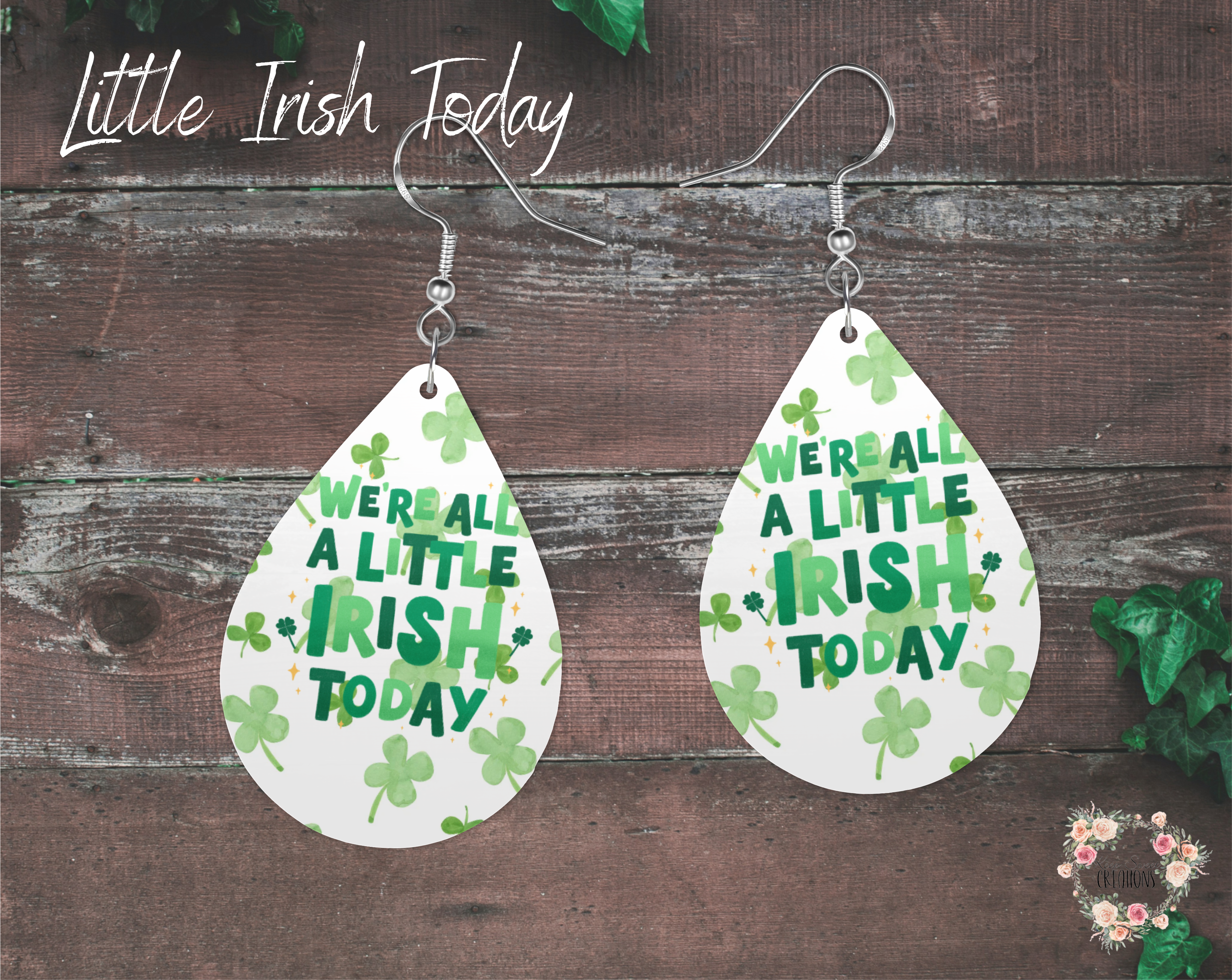 "A pair of teardrop-shaped St. Patrick’s Day earrings featuring the phrase ‘We’re All a Little Irish Today’ in bold green text with scattered shamrocks on a white background. These lightweight sublimation wood earrings have nickel-free hypoallergenic hooks, making them a fun and festive accessory."