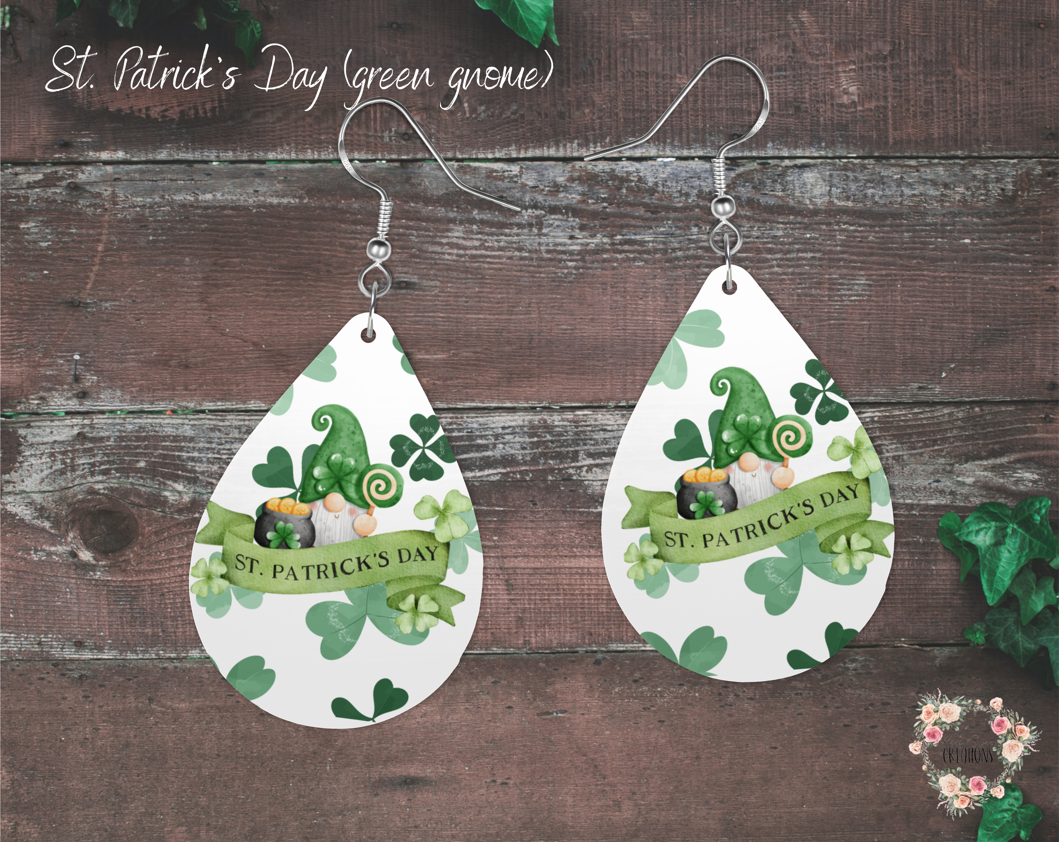 "A pair of teardrop-shaped St. Patrick’s Day earrings featuring a cute green gnome with a shamrock-adorned hat, a pot of gold, and a festive banner that reads 'St. Patrick’s Day.' The background is decorated with green shamrocks. These lightweight sublimation wood earrings have nickel-free hypoallergenic hooks, making them a fun and festive accessory."