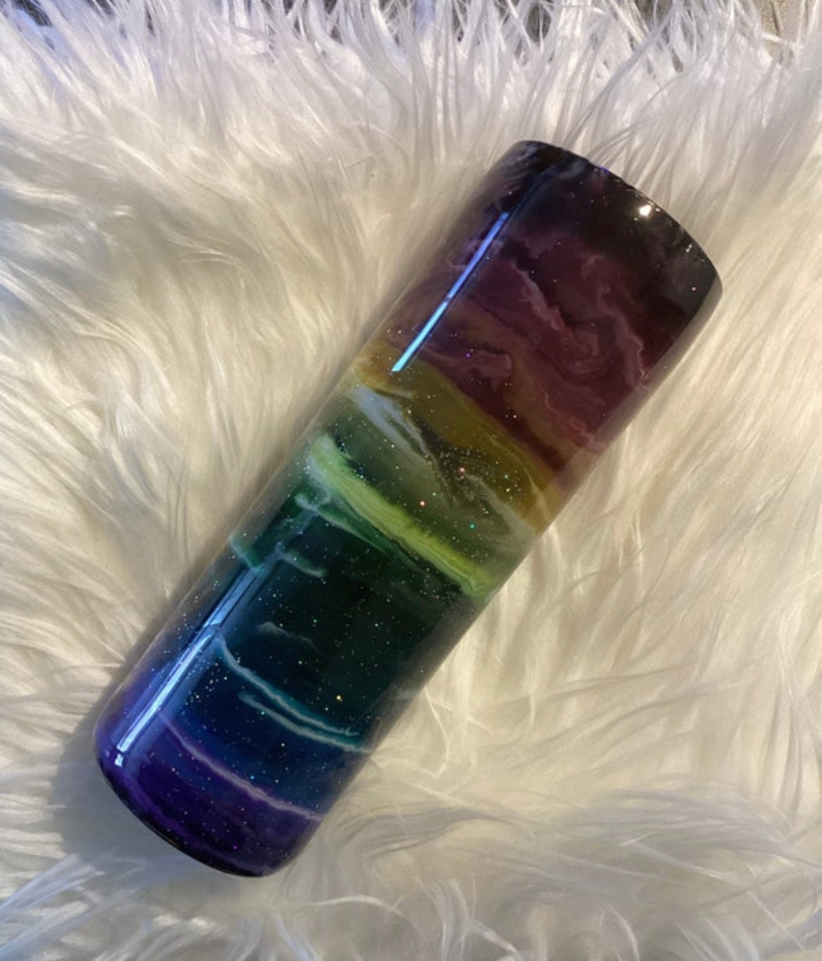 20 oz rainbow glitter tumbler with lid and straw on faux fur background